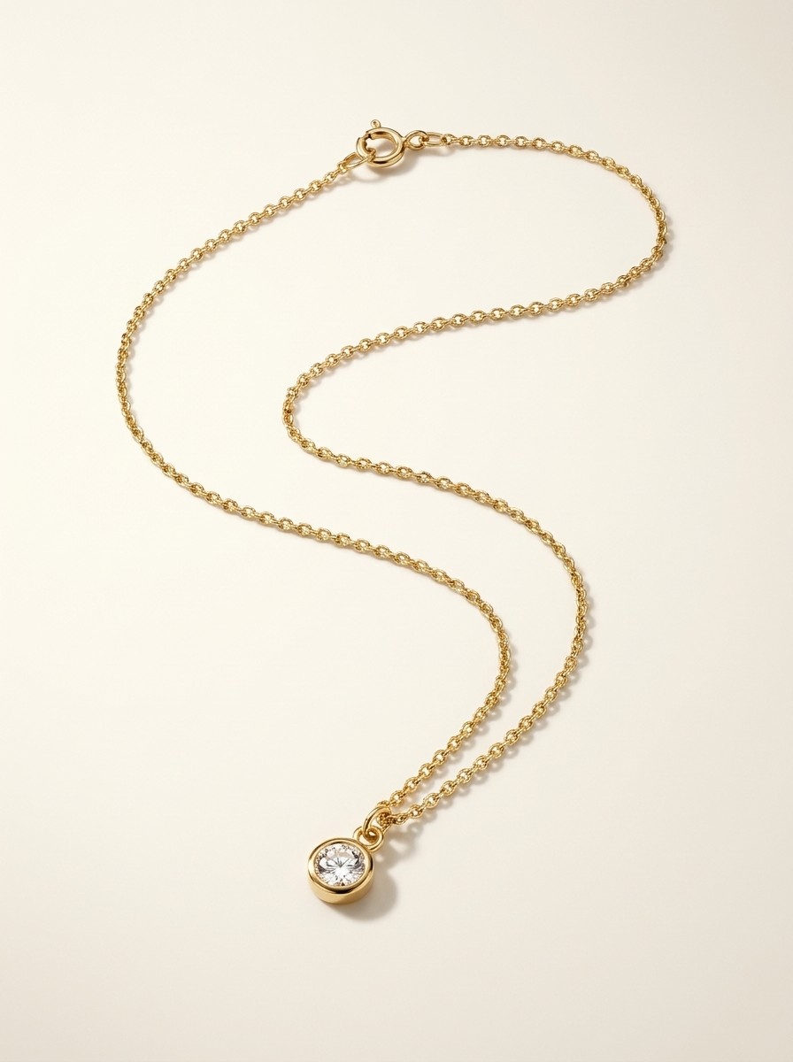 Studio hero shot of the same necklace on a warm-white background